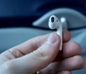 Why Are My AirPods So Quiet - a hand holding one AirPod